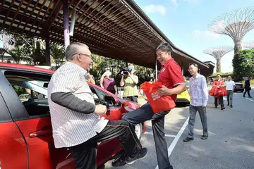 DEKAT DENGAN PEKERJA DAN MASYARAKAT: Kemesraan terpapar antara Encik Ng Chee Meng dan pekerja dalam gambar ini, semasa beliau menjalankan peranannya sebagai ketua buruh. Pemimpin kesatuan berkata Encik Ng banyak membantu dalam latihan dan transformasi pekerja, serta seorang yang rendah hati. - Foto fail ZAOBAO 