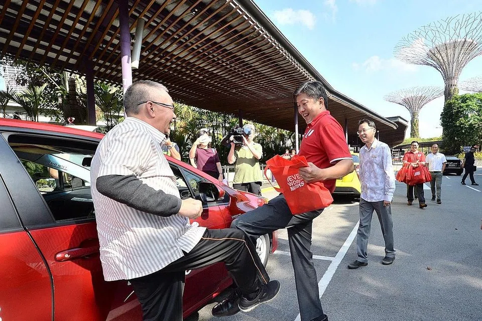 DEKAT DENGAN PEKERJA DAN MASYARAKAT: Kemesraan terpapar antara Encik Ng Chee Meng dan pekerja dalam gambar ini, semasa beliau menjalankan peranannya sebagai ketua buruh. Pemimpin kesatuan berkata Encik Ng banyak membantu dalam latihan dan transformasi pekerja, serta seorang yang rendah hati. - Foto fail ZAOBAO 