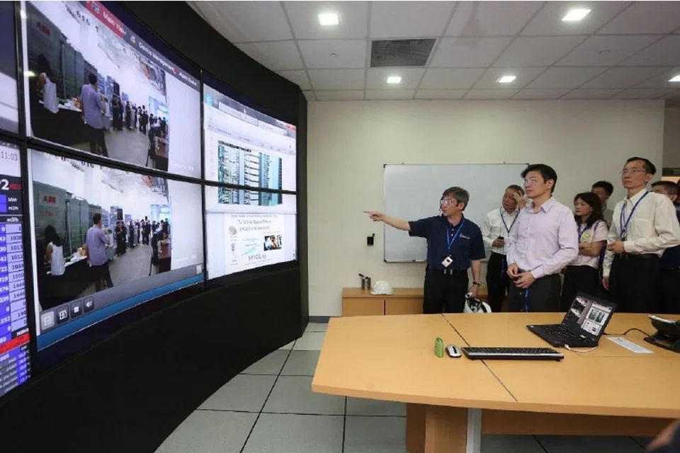 SISTEM PENDINGINAN BAWAH TANAH: Encik Wong (dua dari kiri) meninjau sistem rangkaian pendinginan daerah bawah tanah Singapore District Cooling (SDC) yang berupaya membantu bangunan di kawasan kewangan Marina Bay menjimatkan tenaga. 