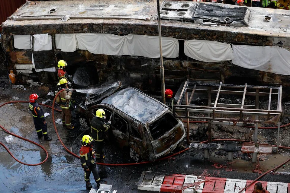 Anggota penyelamat Thailand memadamkan kebakaran dan menyelamatkan penumpang susulan nahas antara sebuah kereta api barangan dengan sebuah bas di Bangkok, Thailand, pada 16 Mei 2026.