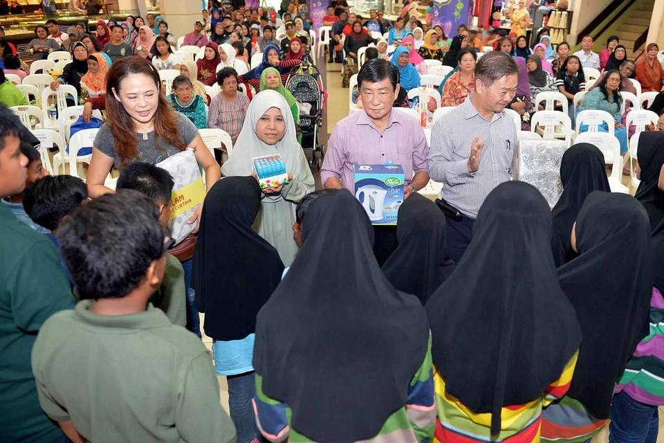 SEBAR KECERIAAN MENJELANG RAMADAN: Pekedai di Joo Chiat Complex tampil menderma barang bagi acara membeli-belah sambil beramal demi mengumpul dana untuk kanak-kanak dari Rumah Kanak-Kanak Pertapis. - Foto M.O. SALLEH