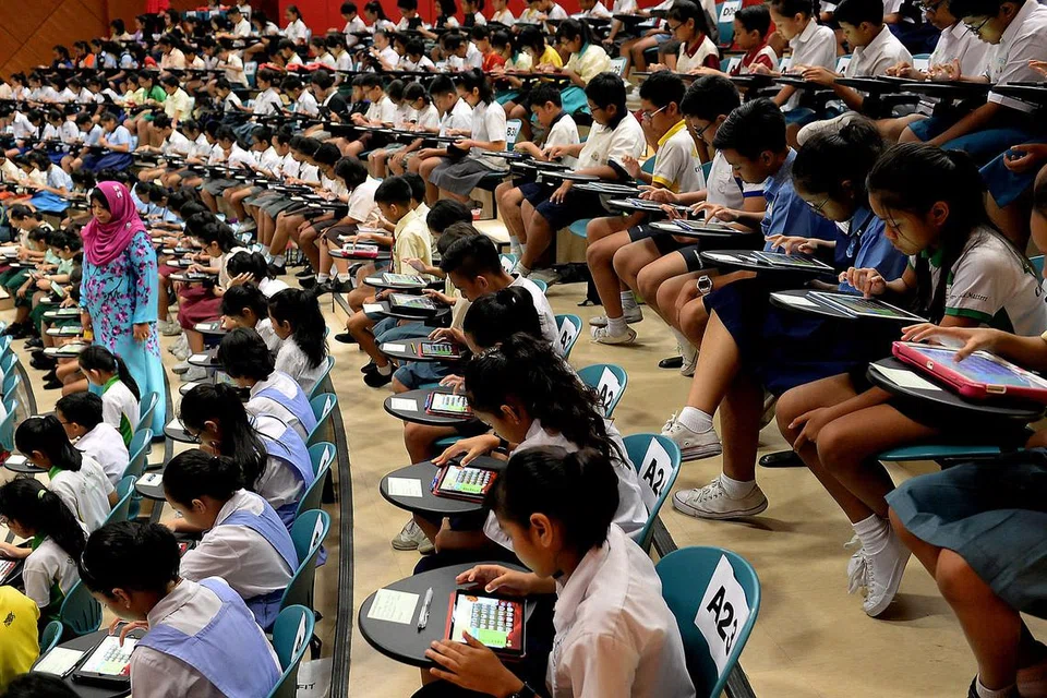 KHUSYUK SERTAI PERTANDINGAN PINTAR KATA: Pusat Bahasa Melayu Singapura (MLCS) telah menganjurkan peraduan yang disertai seramai 282 murid daripada 62 sekolah. - Foto KHALID BABA