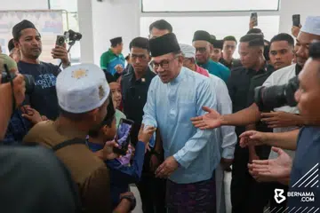 Perdana Menteri Malaysia, Datuk Seri Anwar Ibrahim (tengah), beramah mesra dengan anggota jemaah sebelum menunaikan solat Jumaat di Masjid Bandar Teknologi Kajang, Selangor, pada 19 April.