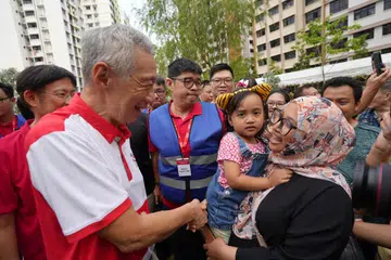 Perdana Menteri, Encik Lee Hsien Loong (depan, kiri), beramah mesra bersama para penduduk Fernvale di acara Hari Ibu pada 12 Mei