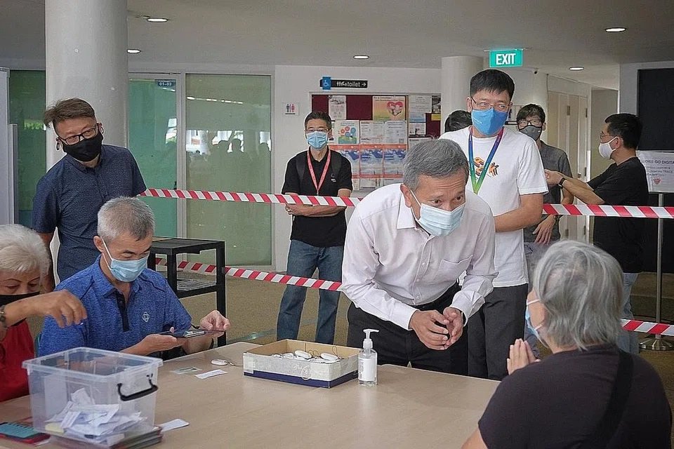 TOKEN TRACETOGETHER: Menteri Bertanggungjawab Inisiatif Negara Bijak, Dr Vivian Balakrishnan sempat beramah mesra dengan seorang penduduk warga emas semasa berkunjung ke pusat pengagihan token TraceTogether di Kelab Masyarakat Kampong Kembangan semalam. - Foto BH oleh GAVIN FOO