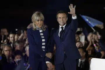IKRAR KHIDMAT KEPADA SEMUA: Encik Macron dan isterinya Brigitte semasa meraikan kemenangan Encik Macron di pilihan raya presiden semalam. Encik Macron berkata beliau akan berkhidmat untuk membantu semua rakyat Perancis, antaranya dalam isu kos sara hidup. - Foto REUTERS