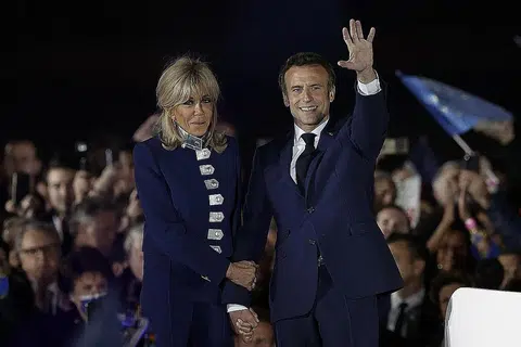 IKRAR KHIDMAT KEPADA SEMUA: Encik Macron dan isterinya Brigitte semasa meraikan kemenangan Encik Macron di pilihan raya presiden semalam. Encik Macron berkata beliau akan berkhidmat untuk membantu semua rakyat Perancis, antaranya dalam isu kos sara hidup. - Foto REUTERS