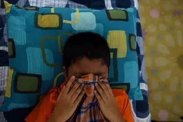 Seorang budak lelaki Malaysia menutup mukanya ketika dikhatankan dalam satu majlis di Masjid Bandar Tun Hussein Onn di Kuala Lumpur pada 11 Disember 2016.