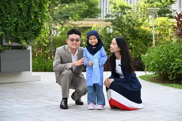 Sumayyah bersama pakar neonatologi, Dr Alvin Ngeow (kiri) dan pakar bedah plastik, Dr Cheryl Hui, yang banyak membantunya dan berharap dia dapat hidup seperti kanak-kanak biasa.