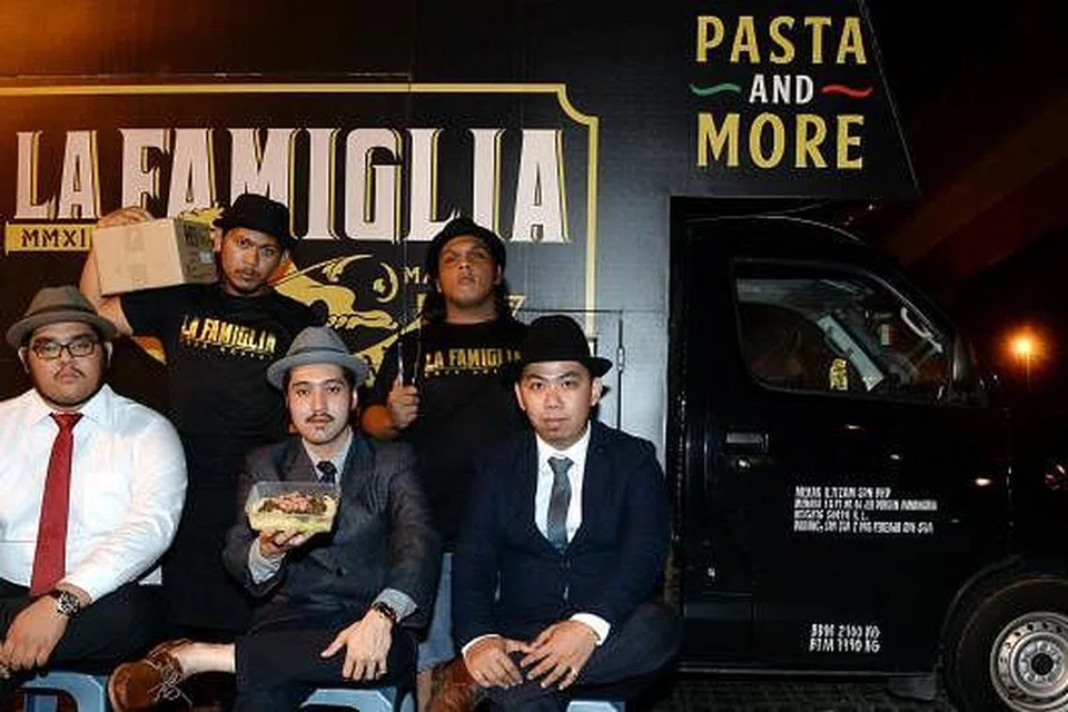 BAWA 'ITALY' KE MALAYSIA: Perintis industri trak makanan di Malaysia, La Famiglia, terkenal dengan gaya ala Mafia yang digayakan bos, Encik Danial Maridz (duduk, kanan) dan Encik Syazwan Khairuddin (duduk, tengah) serta kru mereka, Encik Syahmi Sharuddin (duduk, kiri), Encik Zulfiqar Hadi (belakang, kiri) dan Encik Syafiq Ehasya.