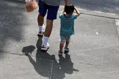 Seorang anak dipimpinan erat bapanya (gambar hiasan).