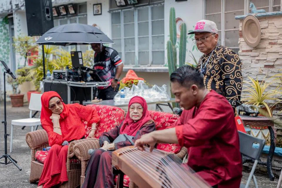 Seniwati Dayang Sofia (kiri) dan Zaiton Abdullah (dua dari kiri) terpaku mendengar petikan ‘gu zheng’ Mohamed Faizal Mohamed Salim (kanan) yang memainkan lagu-lagu lama, sambil diperhatikan pengacara, Eddy Ali.