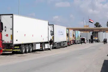 SIAP SEDIA: Sekitar 100 trak yang sarat membawa bantuan kemanusiaan beratur panjang di pintu masuk lintasan Rafah di bahagian Mesir untuk disalurkan kepada rakyat Palestin di Gaza.