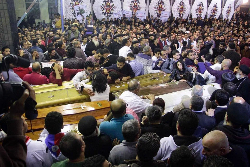 MANGSA TERORISME: Penganut Kristian Mesir berdiri mengelilingi keranda dan meratapi kematian mangsa serangan ganas yang berlaku di dua gereja sewaktu mereka menghadiri acara keagamaan di Gereja Ortodoks Koptik Mar Girgis di Bandar Delta Nil di Tanta, dan di Gereja St Marks di Iskandariah pada 9 April lalu. - Foto AFP