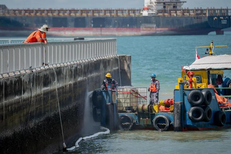 Para pekerja membersihkan kesan minyak yang terdapat di permukaan lebih sukar dicapai di Pantai East Coast pada 28 Jun.