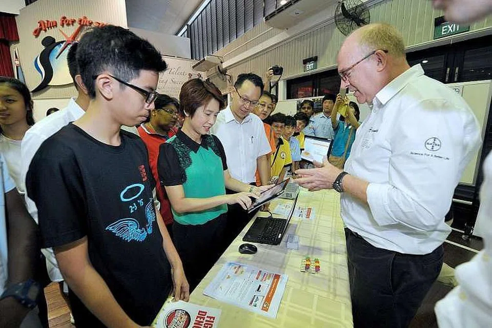  (Dari kiri) Pelajar Sekolah Menangah Jurong, Dario Ng; Mayor Low Yen Ling; dan penasihat pertubuhan akar umbi GRC Jurong, Dr Tan Wu Meng, mencuba kuiz mengenai denggi dengan bimbingan Encik Jason Nash (kanan), pengurus inovasi dan pemimpin kawalan vektor di Bayer. 