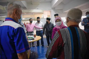 BERI SOKONGAN: Presiden Halimah Yacob bertemu dengan dua gelandangan Encik Lim (kiri) dan Encik Zainul (kanan), yang pernah memanfaatkan program S3P, ketika lawatan beliau ke Masjid Assyakirin semalam. - Foto BH oleh MARK CHEONG