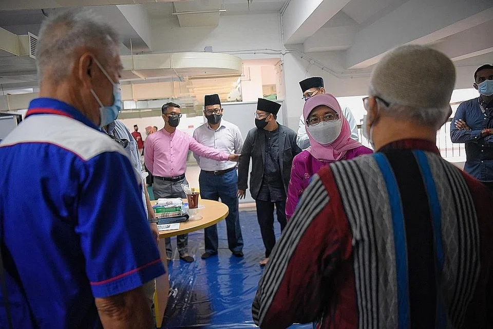 BERI SOKONGAN: Presiden Halimah Yacob bertemu dengan dua gelandangan Encik Lim (kiri) dan Encik Zainul (kanan), yang pernah memanfaatkan program S3P, ketika lawatan beliau ke Masjid Assyakirin semalam. - Foto BH oleh MARK CHEONG