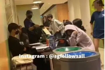 GARA-GARA TEMPAT DUDUK: Seorang lelaki berpakaian hitam bertengkar dengan sekumpulan pelajar di Our Tampines Hub pada Isnin.