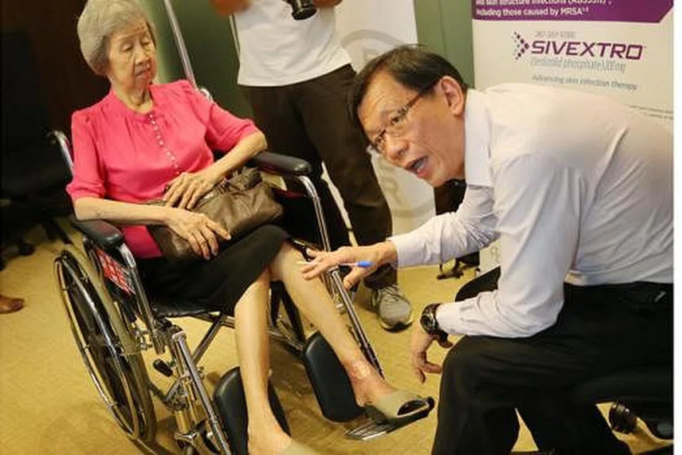 KESAN JANGKITAN MRSA: Pakar penyakit jangkitan, Dr Leong Hoe Nam, menunjukkan kesan MRSA yang dialami Cik Gan di kaki kirinya. - Foto THE STRAITS TIMES