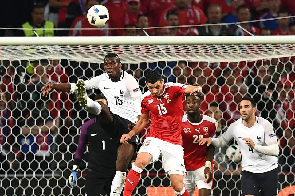 AKSI CEMERLANG: Pemain muda berbakat Perancis, Paul Pogba (kiri), cuba melepaskan percubaan sekalipun cuba diadang pemain Switzerland, Blerim Dzemaili. - Foto AFP