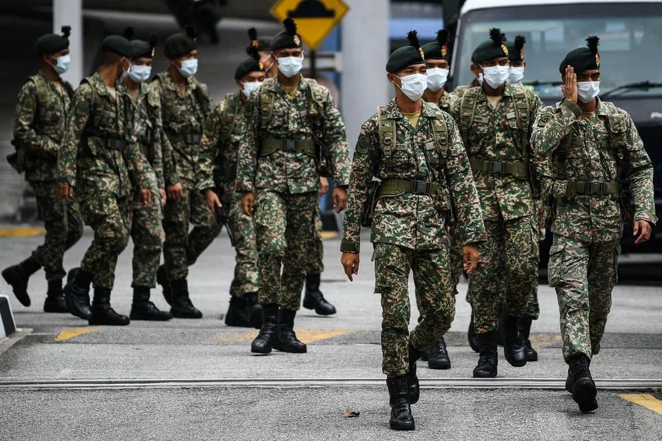 ASKAR DIKERAH: Beberapa askar Angkatan Tentera Malaysia dilihat sedang keluar dari balai polis sebelum dikerah ke beberapa sekatan jalan raya di Kuala Lumpur pada 22 Mac 2020. FOTO:AFP.