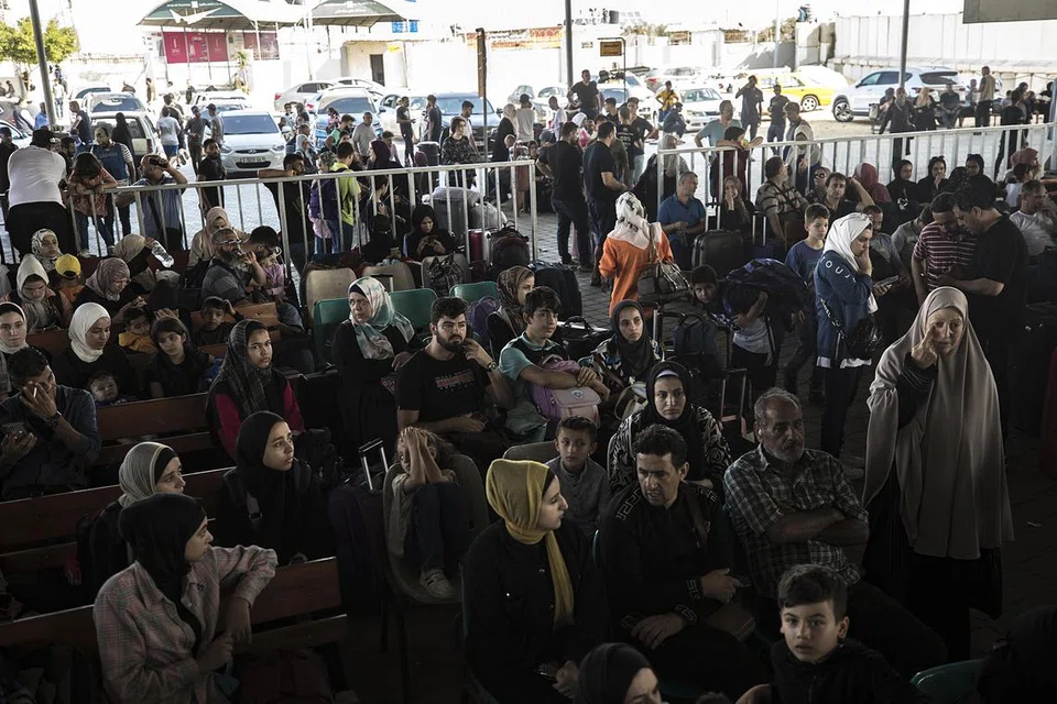 LEGA TIDAK TERKIRA: Rakyat Palestin yang memegang dua kerakyatan dan warga asing menunggu di lintasan Rafah di bahagian Gaza, untuk menyeberang ke Mesir pada Rabu. 