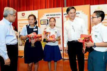 TIGA PEMENANG APLIKASI 'PINTAR KATA': Encik Mohamed Noh Daipi (kiri) dan Encik Saktiandi Supaat (dua dari kanan) bersama pemenang peraduan 'Pintar Kata', Sofea Nurbaqya Abdul Rahman (dua dari kiri), Siti Nur Alisa (tengah) dan Erry Qirriawan Rosli (kanan). - Foto KHALID BABA