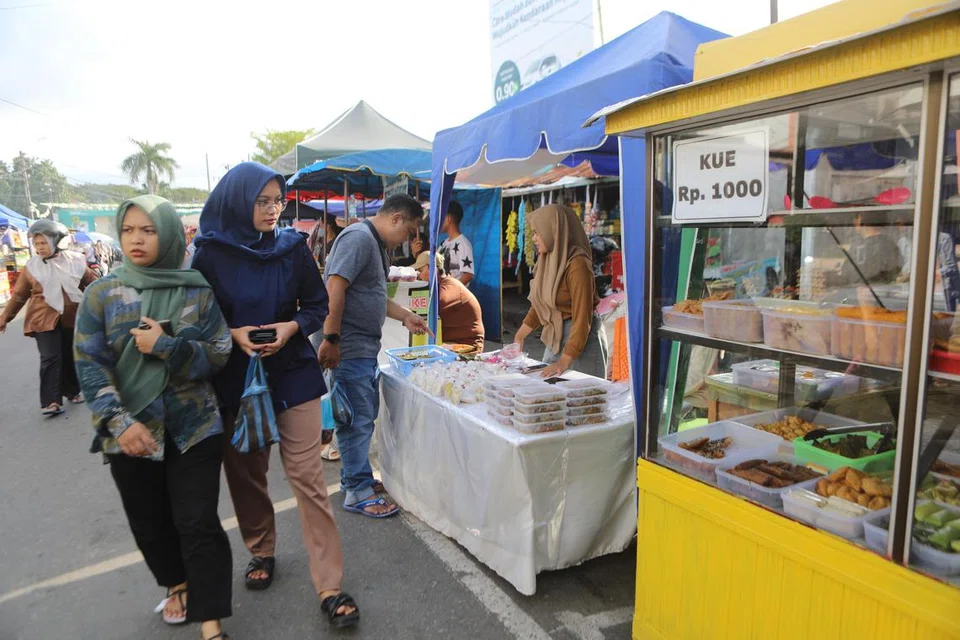 Orang ramai mengunjungi pasar kilat Iftar sempena bulan suci Ramadan di Banda Aceh, Indonesia, pada 11 Mac 2025 sedang pemerintah mengumumkan pembayaran bonus kepada penjawat awam.