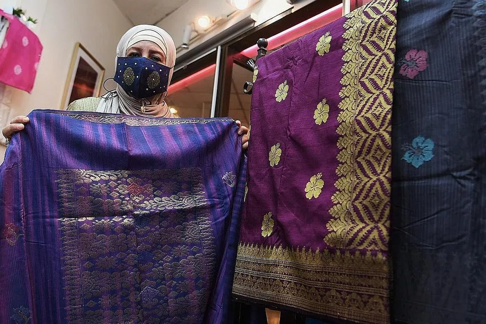 TERPAKSA TURUNKAN HARGA PAKAIAN: Cik Maimunah menurunkan harga pakaian yang dijual kecuali songket. - Foto fail 