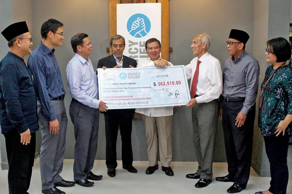HULUR DERMA: (Dari kiri ke kanan) Pengerusi Eksekutif Masjid An-Nur, Encik Khalid Shukur Bakri; Timbalan Ketua Eksekutif Majlis Ugama Islam Singapura (Muis), Encik Esa Masood; Pengarah Eksekutif Mercy Relief, Encik Nasaruddin Shafawi; Ketua Eksekutif Muis, Encik Abdul Razak Hassan Maricar; Penasihat Mercy Relief, Encik Abdullah Tarmugi; Pengerusi RLAF, Encik Po'ad Shaik Abu Bakar Mattar; Pengurus Besar Kelompok Masjid Selatan, Encik Paiman Supangat; dan Setiausaha Pertama Ehwal Politik Kedutaan Indonesia, Cik Ade Veronica Christie dalam majlis penyampaian cek bernilai $362,510 bagi membantu mangsa di Sulawesi. - Foto BH oleh SYAZA NISRINA