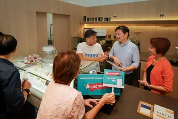 LANCAR BAUCAR CDC TERBARU: Timbalan Perdana Menteri, Encik Lawrence Wong (tengah), bersama Mayor Daerah South West, Cik Low Yen Ling (kanan), mengunjungi sebuah kafe yang menyertai Skim Baucar CDC sewaktu pelancaran baucar terbaru pada 3 Januari.