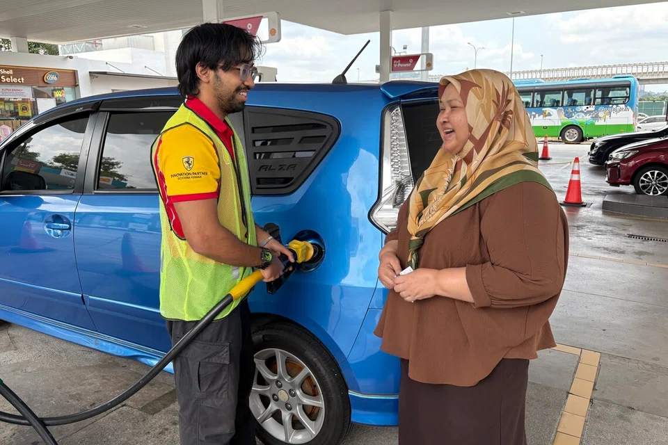 Pembantu pam minyak, Encik Muhd Haffiz Ali Mohamad, membantu pemandu kenderaan swasta, Cik Ruzaimah Rohani, 50 tahun, mendapat penjelasan mengenai inisiatif Budi95 yang dilaksanakan kerajaan Malaysia bermula 30 September ini.  