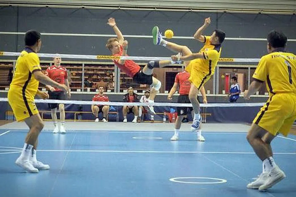 TUNJUK BAKAT: Penyerang Jerman, Sebastian Schrumann (jersi merah) cuba mengadang pukulan Kolonel Komkrit daripada pasukan Thailand dalam Kejohanan Sepak Takraw Antarabangsa De'France yang berlangsung pada 6 September lalu. - Foto-foto ISTAF