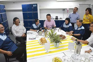 SELESA BEREHAT: Encik Zaqy (kiri) menemui pekerja pembersihan, anggota pergerakan buruh dan kakitangan Ikea di kawasan rehat Ikea Alexandra. Perikatan tiga pihak - MOM, NTUC dan SNEF - melancarkan panduan bagi menyediakan kawasan rehat bagi pekerja sumber luar semalam. Turut hadir di acara itu ialah ASG NTUC Encik Zainal Sapari (duduk, kanan). - Foto BH oleh KELLY HUI