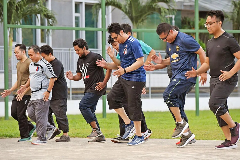 SIHAT JASMANI SIHAT ROHANI: Sekumpulan asatizah menjalani senaman mingguan di bawah bimbingan seorang jurulatih sebagai sebahagian daripada program Asatizah Sihat selama 12 minggu anjuran Muis dan Persatuan Karyawan Penjagaan Kesihatan Islam (MHPA). - Foto BH oleh DESMOND FOO