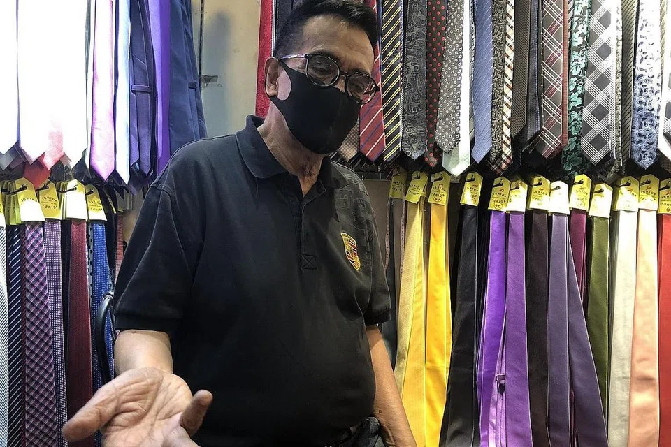 SUASANA LENGANG: Keadaan waktu tengah hari di pekarangan Raffles Place agak sepi. Gambar atas ialah Encik Shaik yang bakal menutup kedainya yang terletak di The Arcade pada hujung bulan depan. - Foto BH oleh NORHAIZA HASHIM