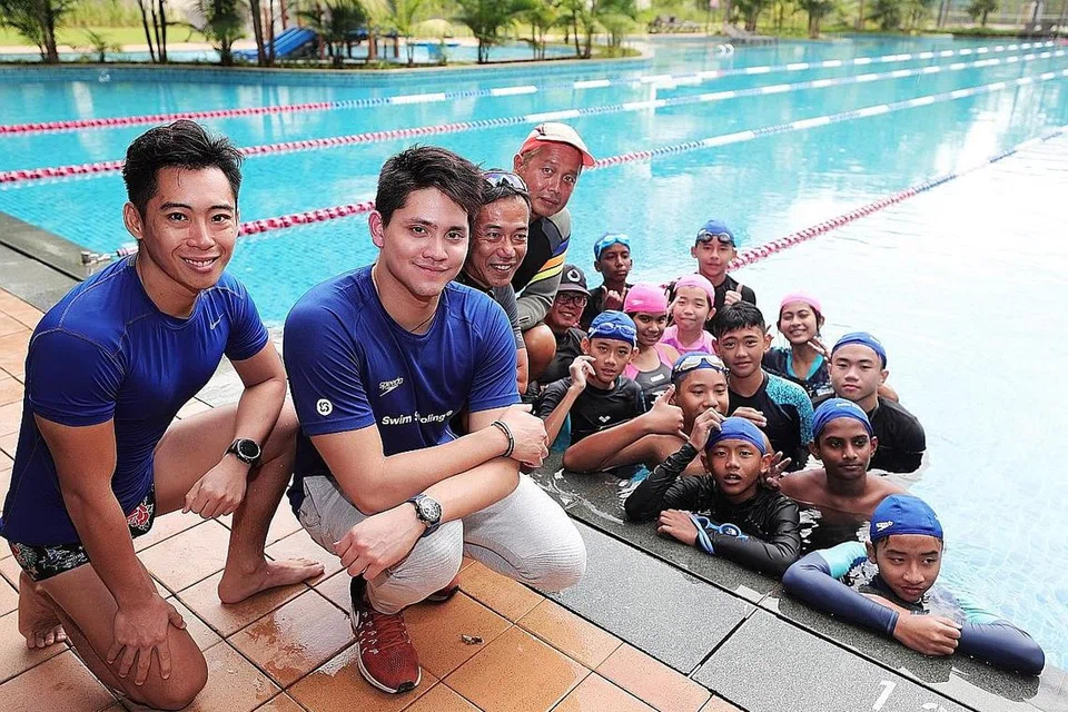 LATIHAN BERSAMA JUARA: 12 belia dari pertubuhan Care Singapura, berpeluang mengikuti latihan yang dikendalikan juara Olimpik negara, Schooling (dua dari kiri) dan jurulatih dari Swim Schooling di kolam renang Kelab Temasek semalam. - Foto BH oleh KELVIN CHNG
