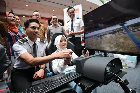 Menteri Negara (Penerangan dan Pembangunan Digital merangkap Kesihatan), Cik Rahayu Mahzam (depan, kanan), sedang mencuba salah satu kegiatan yang disediakan semasa acara ‘Raikan Ilmu@Heartlands’ (Jurong) di Jurong Point. Turut hadir di acara itu ialah Anggota Parlimen (AP) GRC Jurong, Dr Tan Wu Meng (belakang, tiga dari kanan); dan AP GRC Chua Chu Kang, Encik Zhulkarnain Abdul Rahim (belakang, dua dari kanan).