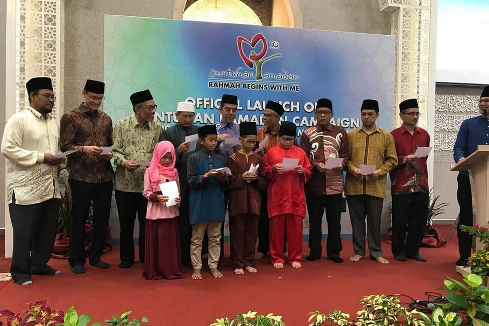 SENTUHAN RAMADAN 2018: Encik Masagos (enam dari kiri) menyertai Haji Abdul Razak (lima dari kiri), Mufti (empat dari kiri), beberapa kakitangan Muis yang lain dan pelajar madrasah aLIVE mengucapkan ikrar Sentuhan Ramadan semasa majlis pelancaran kempen itu.