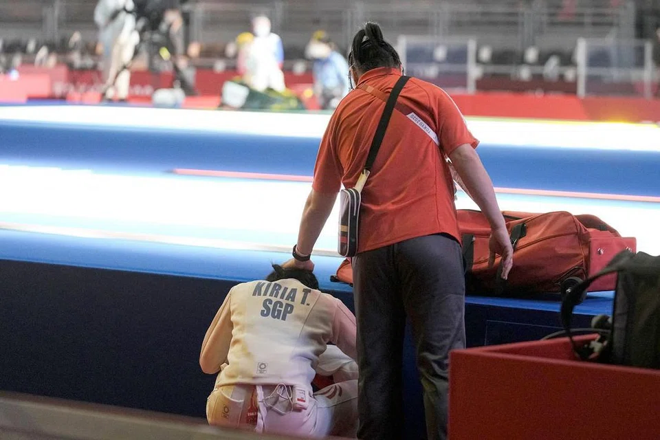 Kiria Tikanah Abdul Rahman (kiri) ditenangkan oleh jurulatihnya Henry Koh (kanan). - Foto SNOC