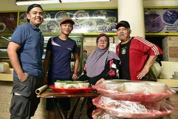 SEMANGAT KEKELUARGAAN: (Dari kiri) Pemilik gerai, Encik Abdul Hadi Mohd Noor, bersama sepupunya, Encik Mohd Syaher Fahmi, dan ibu bapanya, Cik Rahoyah Sudin dan Encik Mohd Noor Pungut di gerai mereka yang menyiapkan hidangan yang dipesan pelanggan. - Foto BH oleh DESMOND WEE