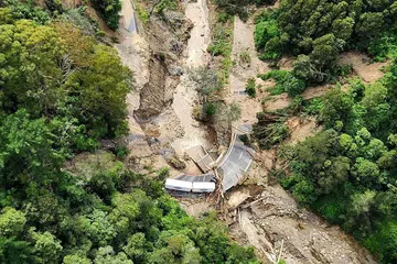 MANA NAK JALAN?: Trak ini dilihat terperangkap dalam runtuhan tanah yang berlaku ekoran Taufan Gabrielle yang melanda New Zealand. - Foto-Foto AFP 