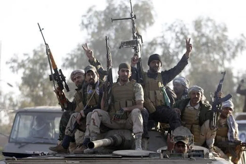 MEMERANGI IS: Tentera Iraq dan pejuang Syiah duduk di atas kereta kebal di wilayah Salahuddin semalam. Mereka telah melancarkan serangan ke atas kubu kuat militan Negara Islam di Tikrit, utara Baghdad. - Foto REUTERS