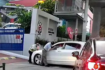 TUKAR NOMBOR PLAT: Rakaman video Neo Hong Chye memandu untuk memasuki Sekolah Red Swastika walau dihalang seorang pegawai keselamatan. Anak Neo, Glynn Neo, menukar nombor plat kereta itu untuk sesi foto bagi menjualnya. - 