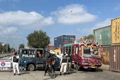 Pegawai polis berkawal di sebuah jalan menuju ke Konsulat Jeneral Amerika Syarikat, beberapa hari selepas protes tercetus susulan pembunuhan pemimpin tertinggi Iran, Ayatollah Ali Khamenei, dalam serangan Amerika Syarikat dan Israel pada 28 Februari, di Karachi, Pakistan, pada 5 Mac 2026. 
Protes besar tercetus di beberapa bandar Pakistan selepas kematian Khamenei, dengan penunjuk perasaan menyerbu konsulat Amerika Syarikat di Karachi dan mencetuskan pertempuran dengan pasukan keselamatan.