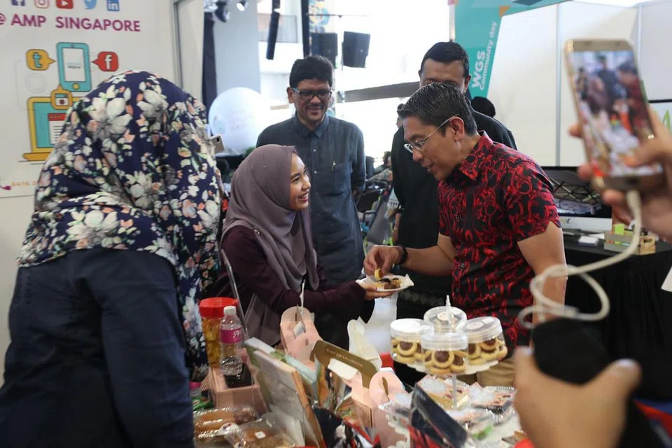 MENGGEMBLENG TENAGA: Dr Mohamad Maliki Osman sedang berbual bersama para kakitangan daripada Angkatan Karyawan Islam (AMP) yang menyediakan reruai di acara Hari Masyarakat Wisma Geylang Serai. - Foto BH oleh TIMOTHY DAVID