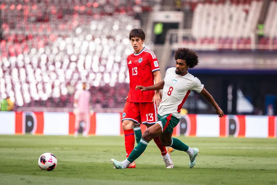 Pemain Bangladesh, Hamza Choudhury (kanan) cuba mendapatkan bola daripada Harhys Stewart dalam perlawanan yang diadakan di Stadium Gelora Bung Karno pada 28 September.