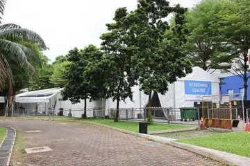 SEDIAKAN KHIDMAT: Khemah dipasang di tempat letak kereta terbuka untuk pemeriksaan batuk kering atau tuberkulosis (TB) pekerja di pusat makanan dan pasar.