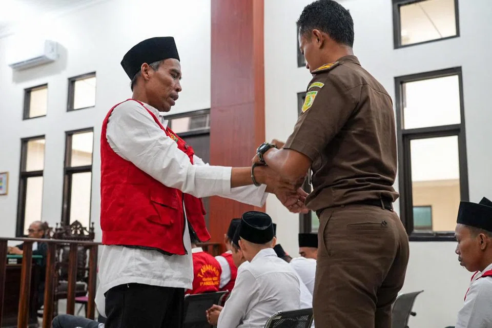 Gambar ini, yang diambil pada 12 Februari 2025 dan dikeluarkan pada 14 Februari 2025 oleh Mahkamah Daerah Pandeglang, menunjukkan seorang pegawai pendakwa membuka gari seorang lelaki semasa perbicaraan pemburu haram yang membunuh puluhan badak Jawa yang jarang ditemui, di bilik mahkamah Mahkamah Daerah Pandeglang di Pandeglang, Wilayah Banten.